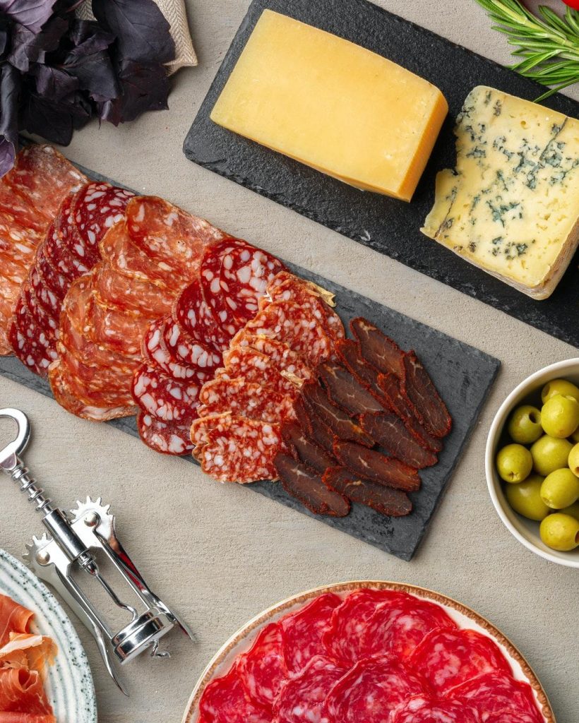 Meat and cheese slicing on gray background